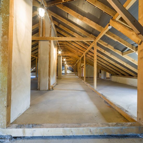 Attic of a building with wooden beams of a roof structure.